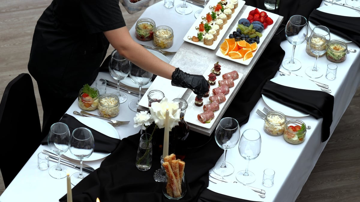 Gourmet appetizers served on crisp white tablecloth with candles