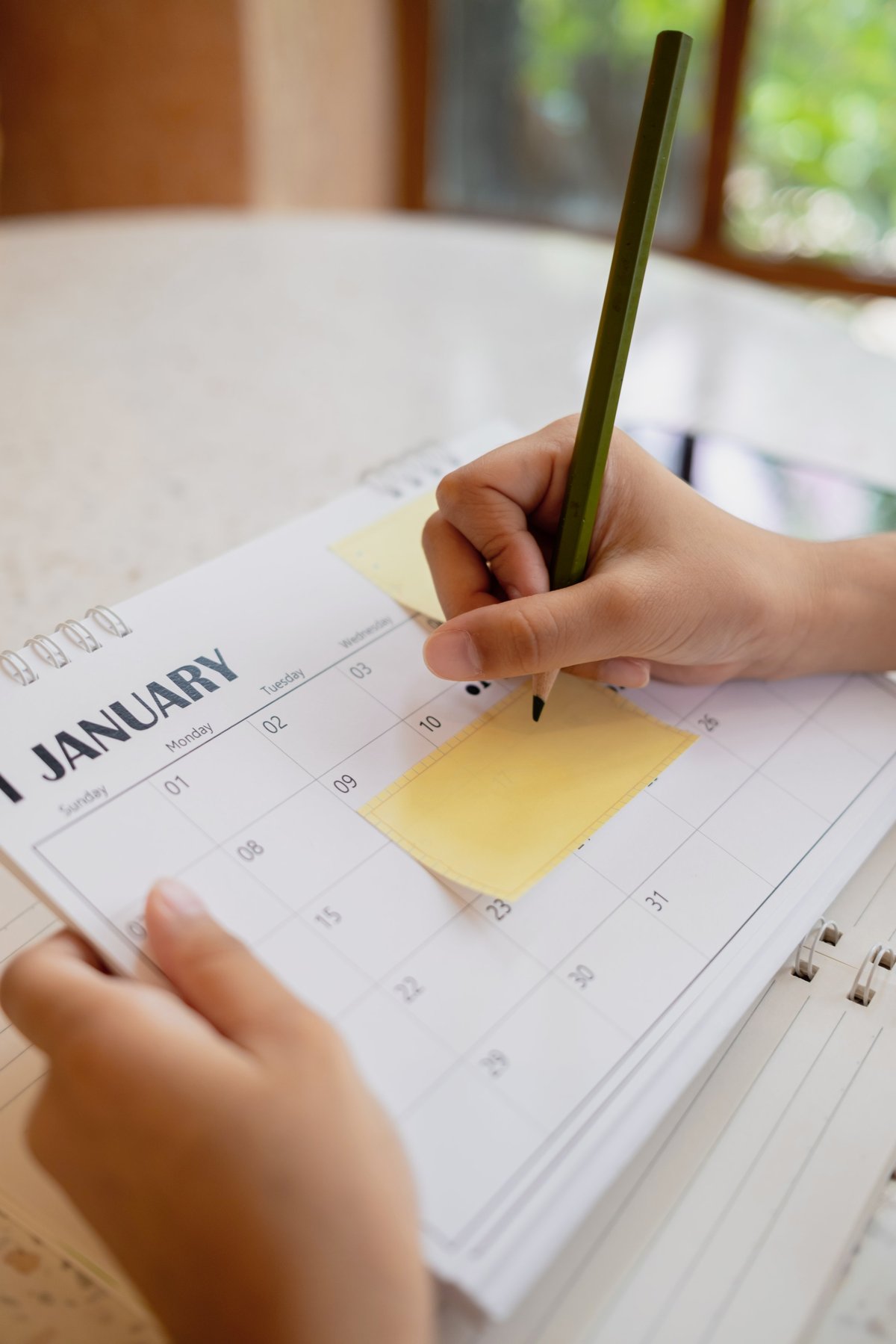 Business woman planning on calendar with sticky notes